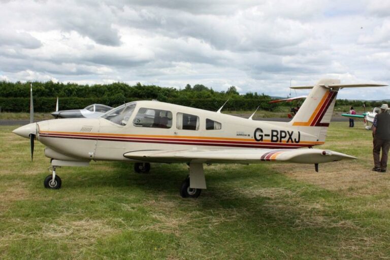 Single-engine plane G-BPXJ on grassy airfield