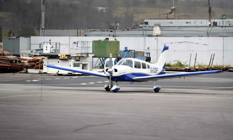 Small blue and white aircraft parked on tarmac