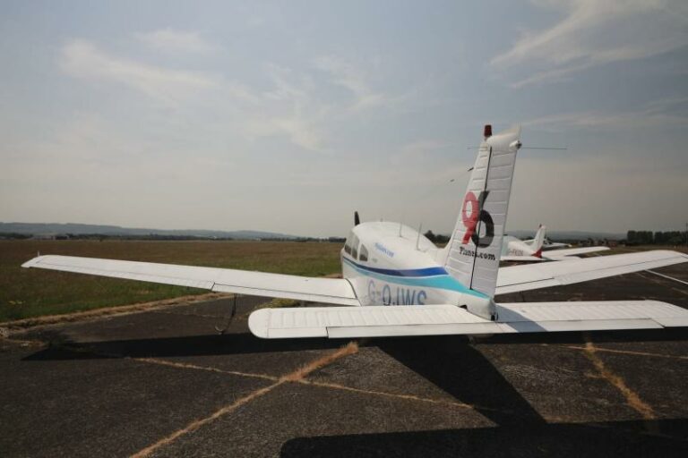 Small aircraft parked on runway in clear weather