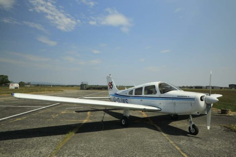 White Piper Warrior III aircraft at sunny airfield