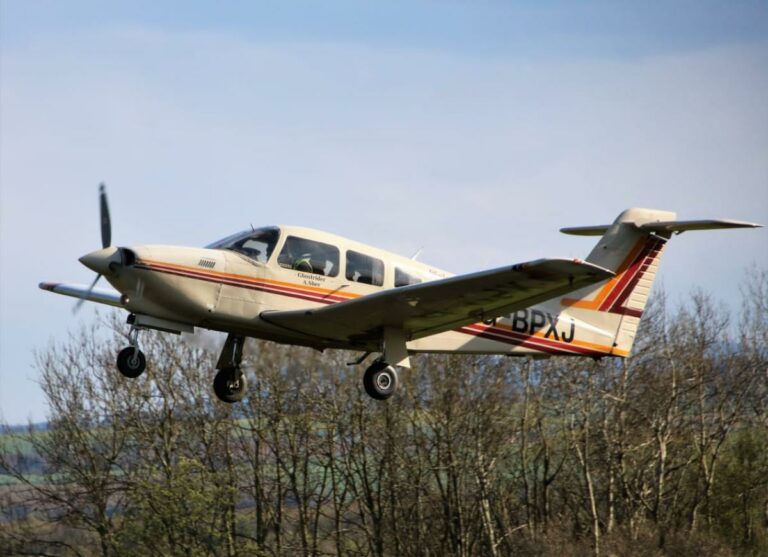 Small aircraft flying over rural landscape
