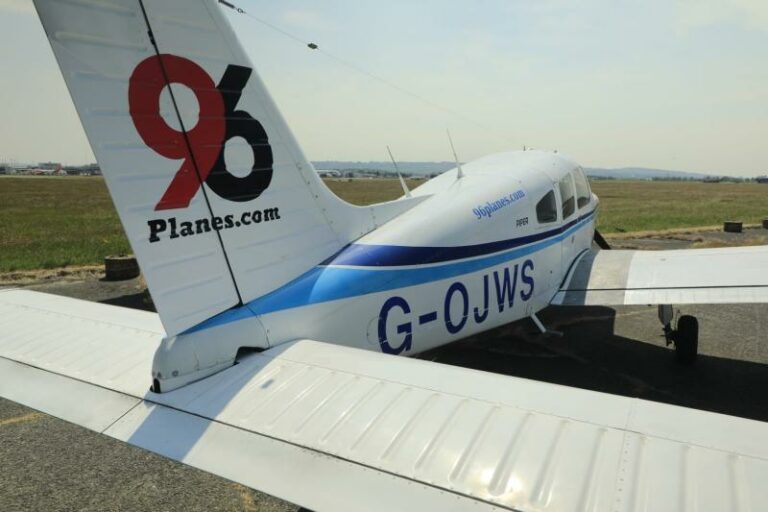Small plane with '96planes.com' on tail at airfield
