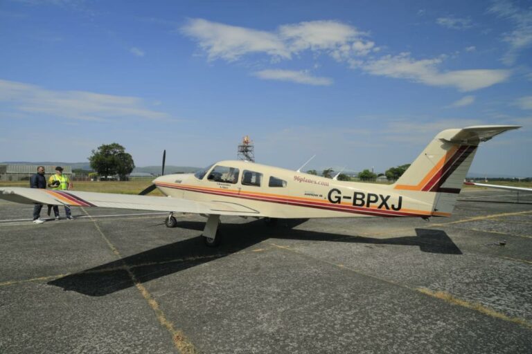 Small aircraft and two people on sunny runway