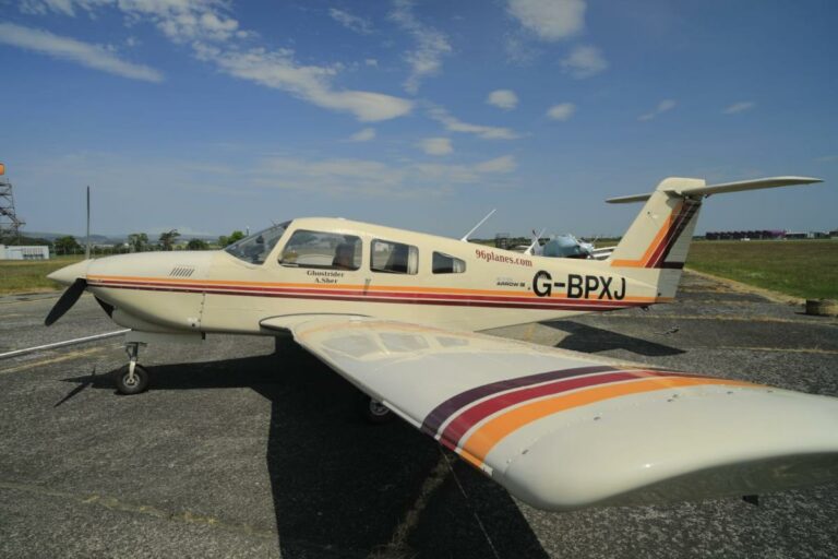 Small aircraft on tarmac under clear sky, labeled G-BPXJ