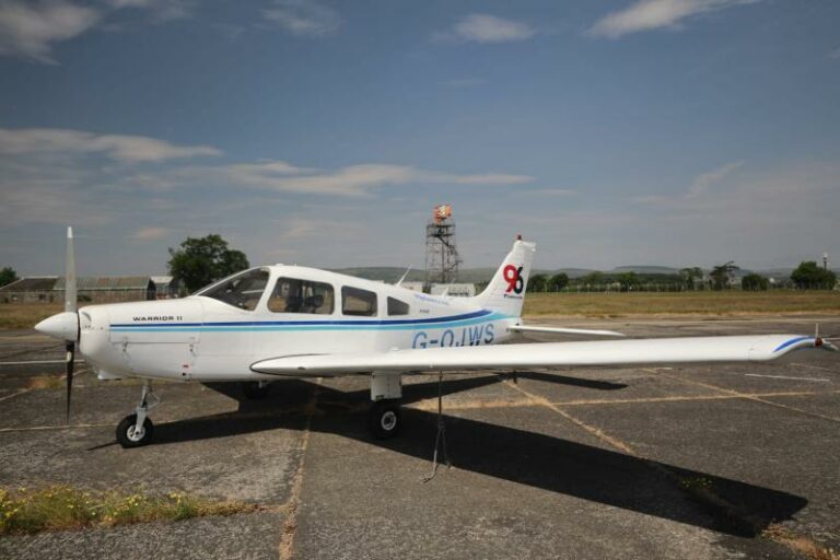 White Warrior II aircraft parked on sunny tarmac