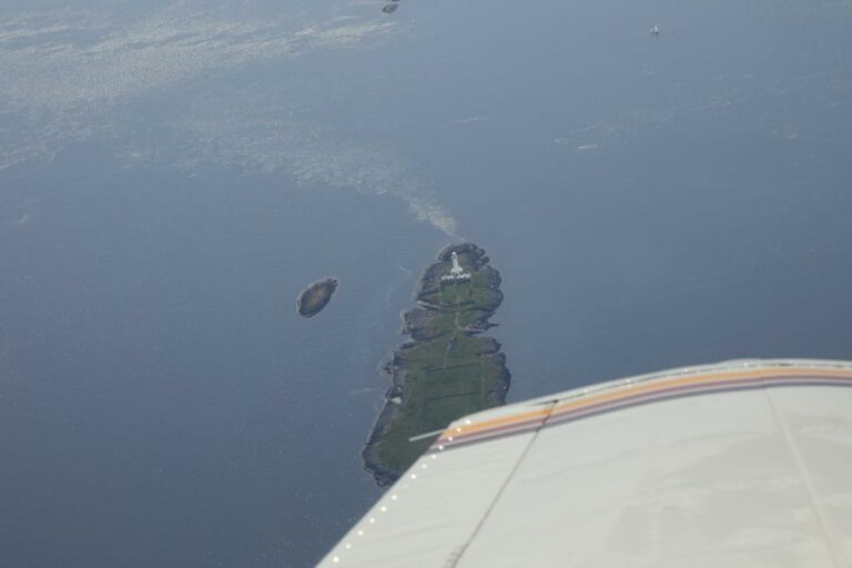 Aerial view of island with lighthouse near coastline