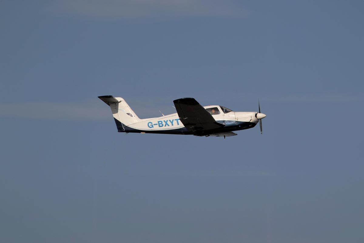 Small aircraft G-BXYT flying in clear blue sky