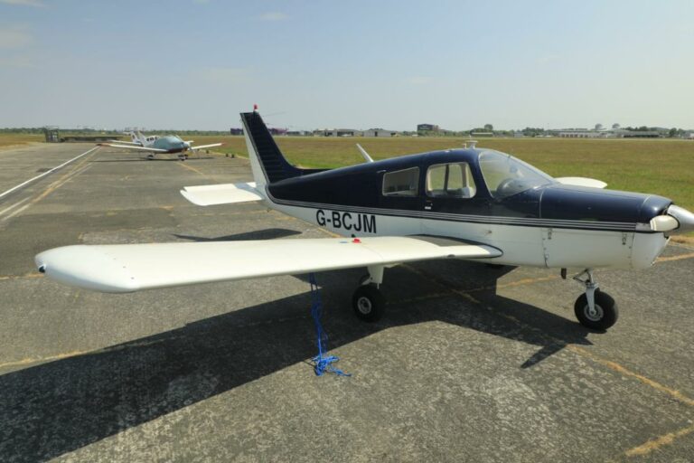 Small airplane parked on sunny airfield