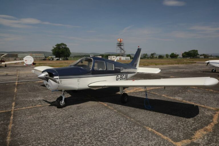Small private aircraft parked on sunny airstrip