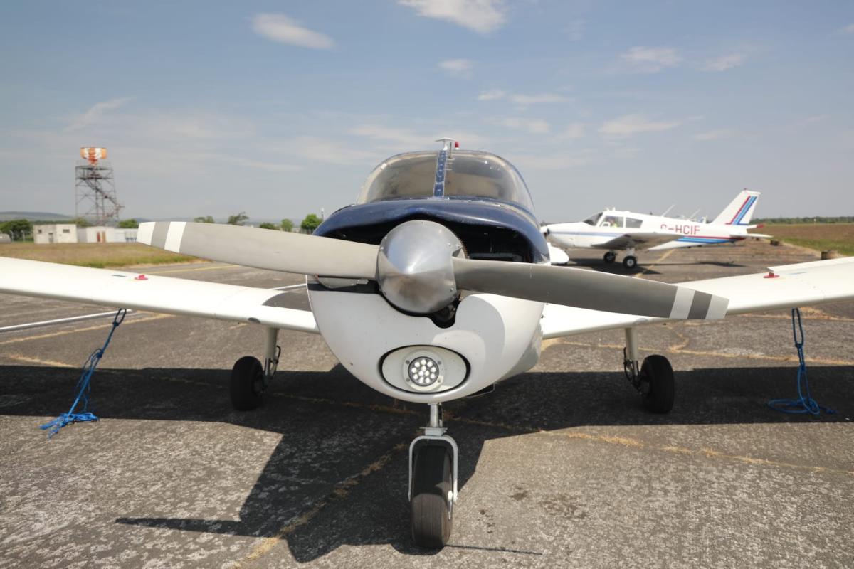 Light aircraft parked on sunny runway